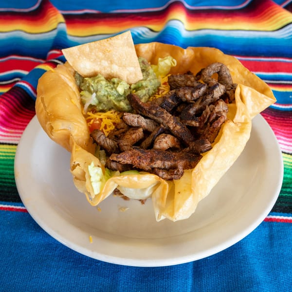 A Town House Restaurant taco salad with steak, guacamole, and cheese in a crispy tortilla bowl.