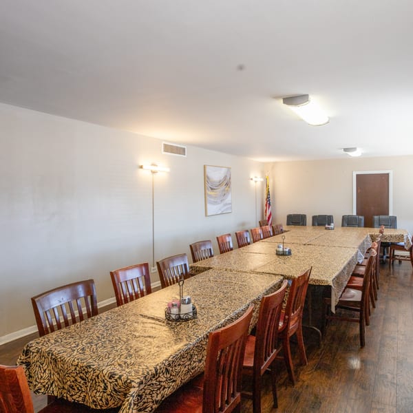 Long tables with patterned tablecloths and wooden chairs in a private dining room at Town House Restaurant.